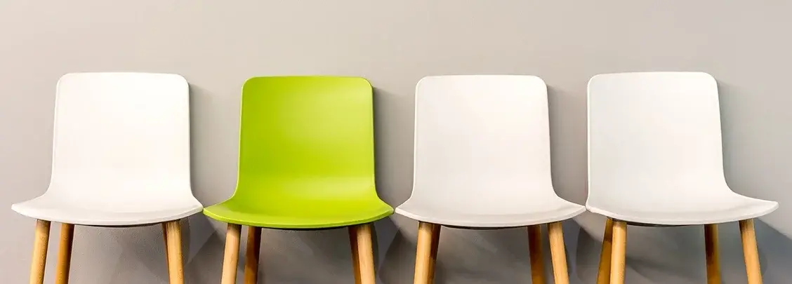 One Green and Three White Aligned Chairs